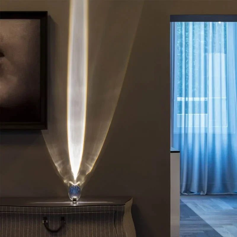 Modern floor lamp with a feather design in a room with a window and curtain.