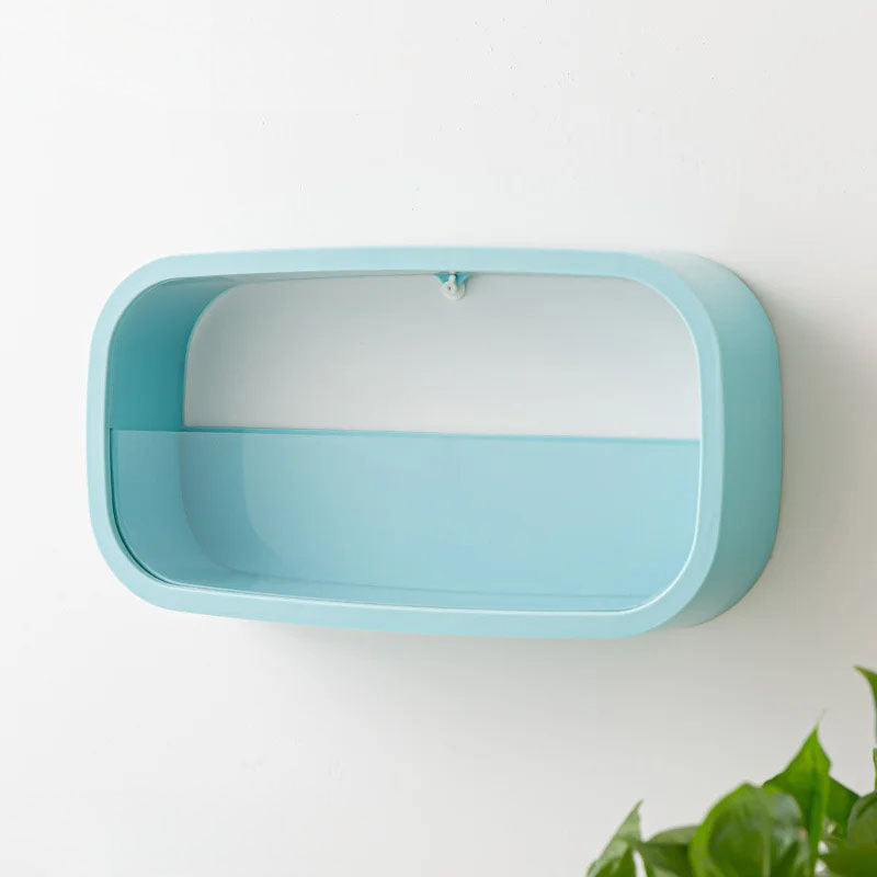 Light blue rectangular shelf on a white wall with a plant in the corner.