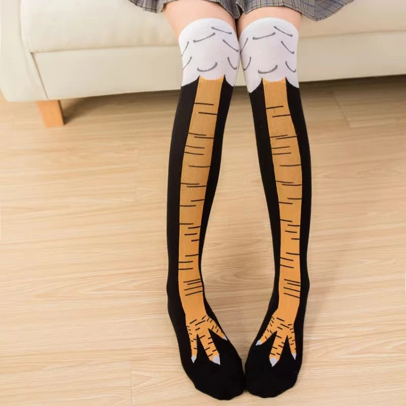 Knee-high socks with bird foot design worn by a person on a wooden floor.