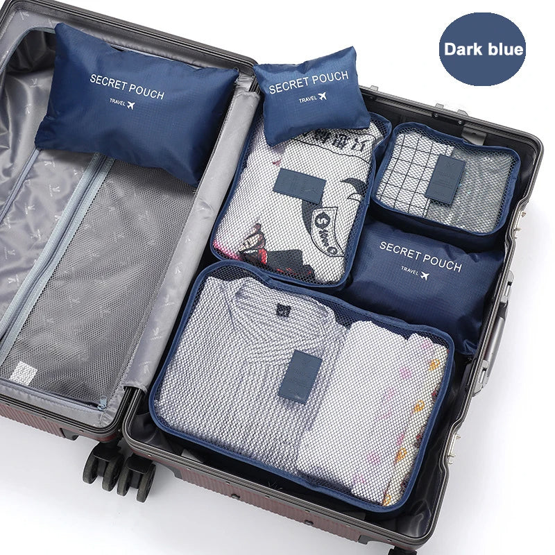 Open suitcase with travel packing cubes labeled 'Secret Pouch' on a white background