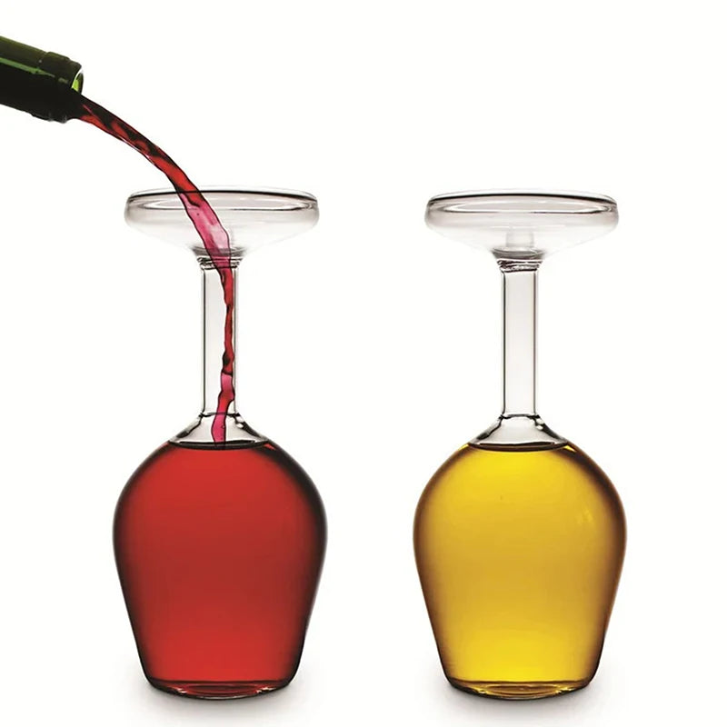 Two wine glasses filled with red and yellow liquids on a white background