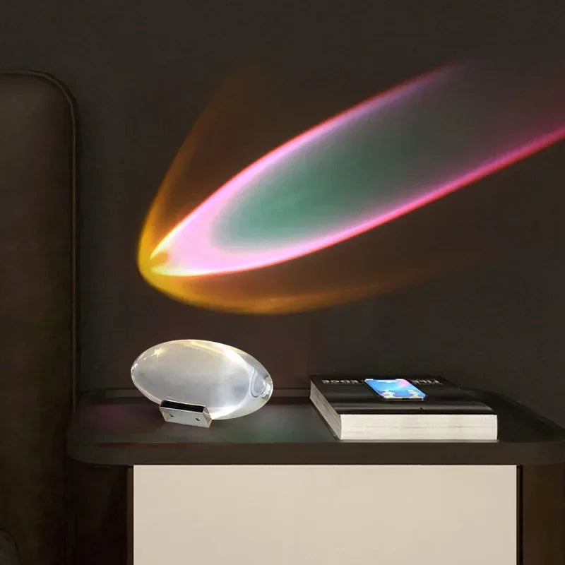 Colorful light projection on a dark wall with a modern lamp and book on a table.