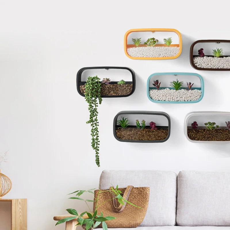 Wall-mounted planters with plants on a white wall above a sofa.
