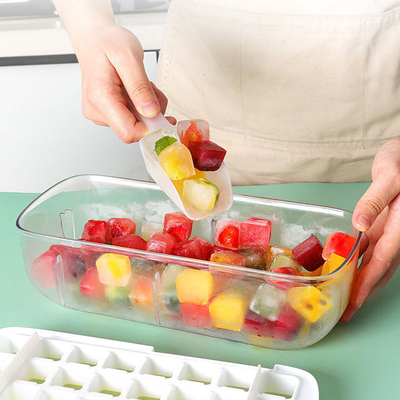 Person using a silicone ice cube tray to extract colorful fruit ice cubes from a container.