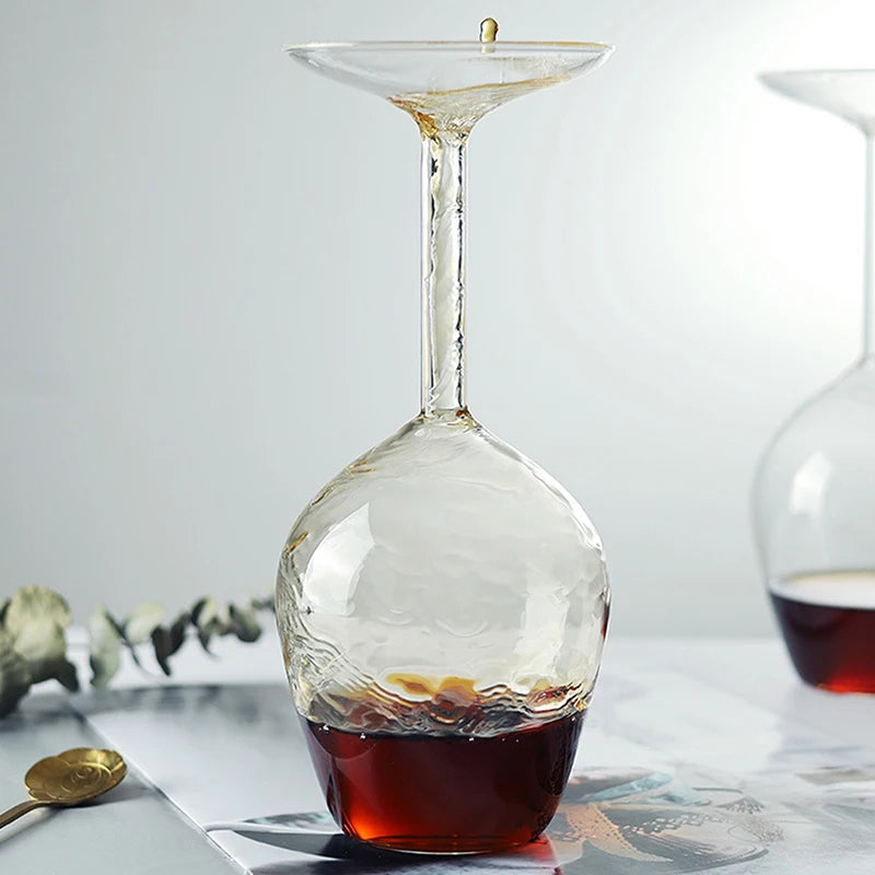 Clear glass decanter with amber liquid on a light surface with a neutral background