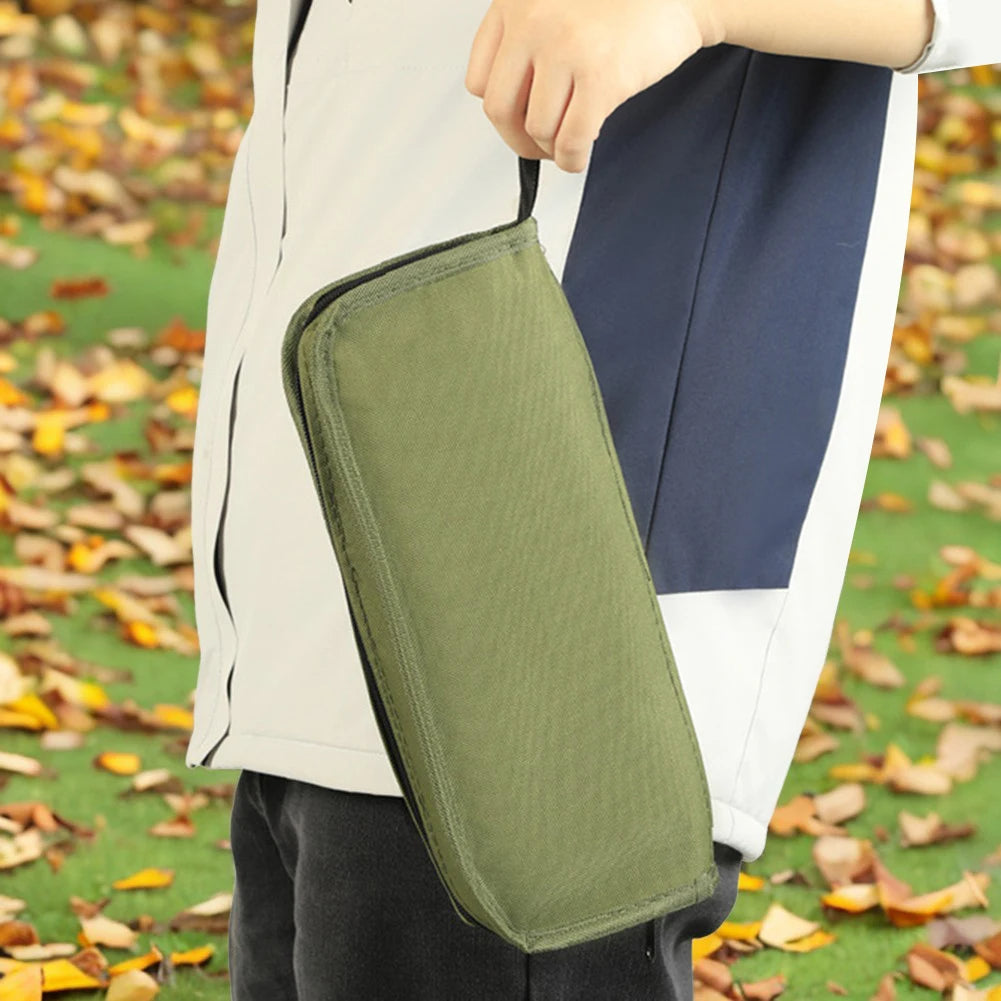 Person holding a green bag with a blurred autumn background