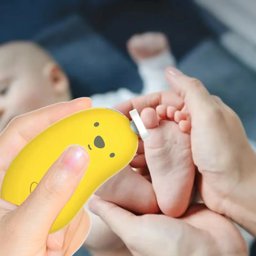 A close-up of hands using a yellow, bear-shaped baby foot care device on a baby's foot, with a blurred baby in the background.