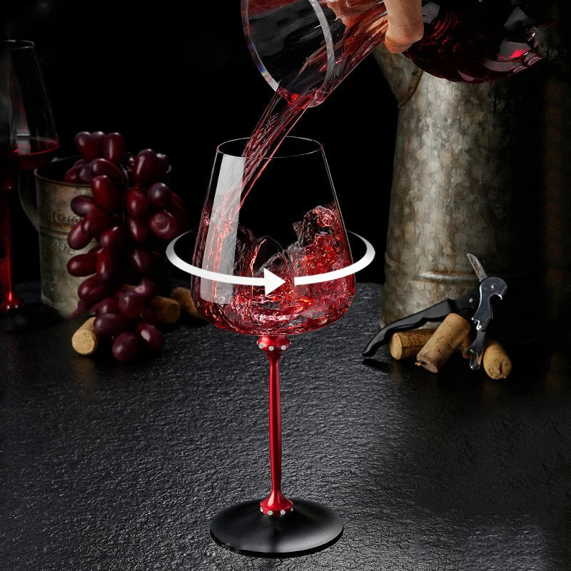 Red wine being poured into a wine glass with grapes and a corkscrew in the background.