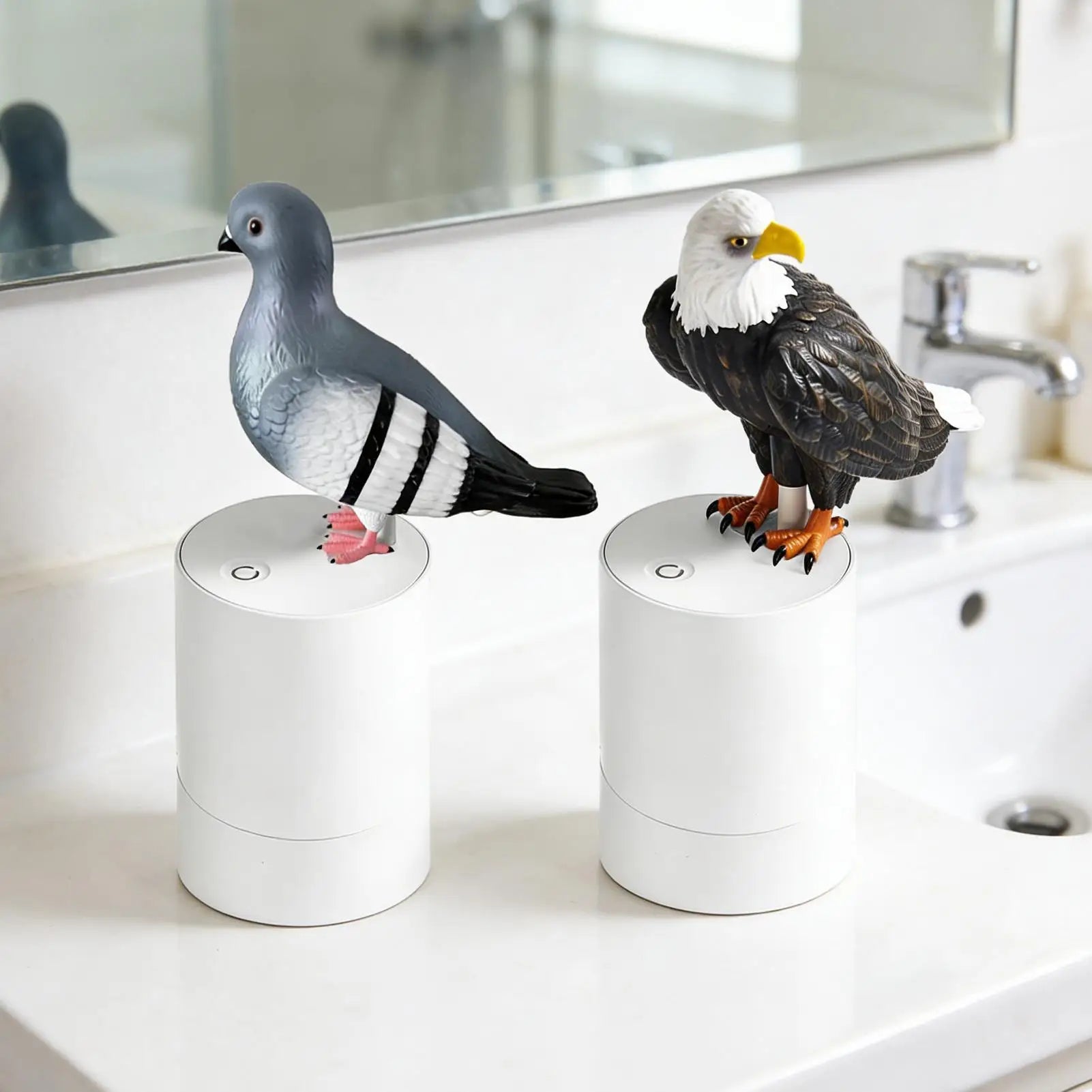 Two bird figurines, one resembling a pigeon and the other an eagle, on white cylindrical objects in a bathroom setting.