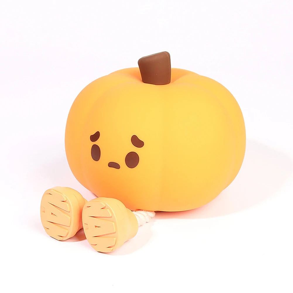 Plush toy shaped like a pumpkin with a sad face on a white background