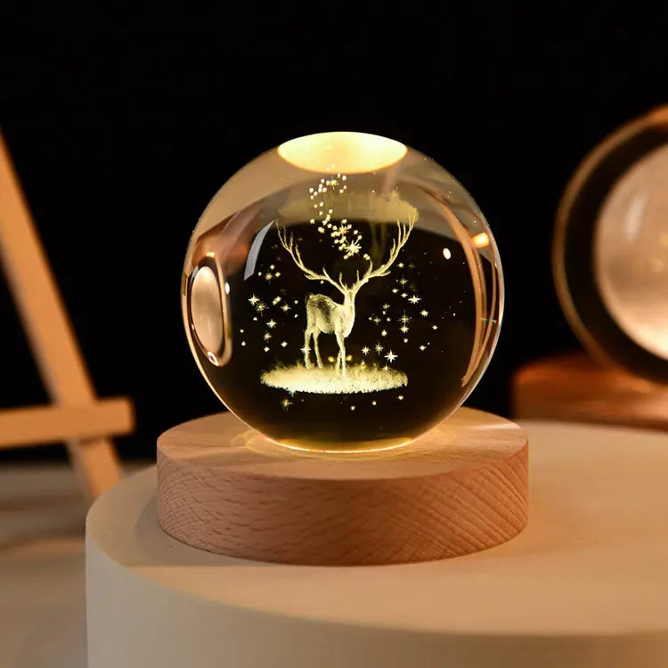 Glowing crystal ball with deer design on a wooden base against a dark background