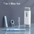 Set of 7 blue and white grooming tools on a gray surface with a dark gray background.