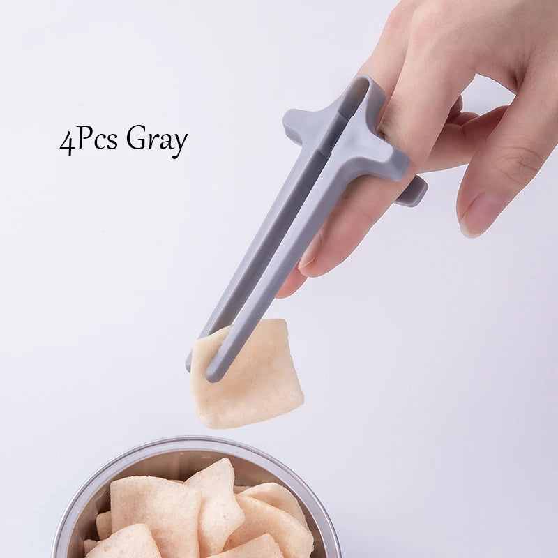 Gray dumpling maker with a hand holding it above a bowl of dumplings on a light gray background.