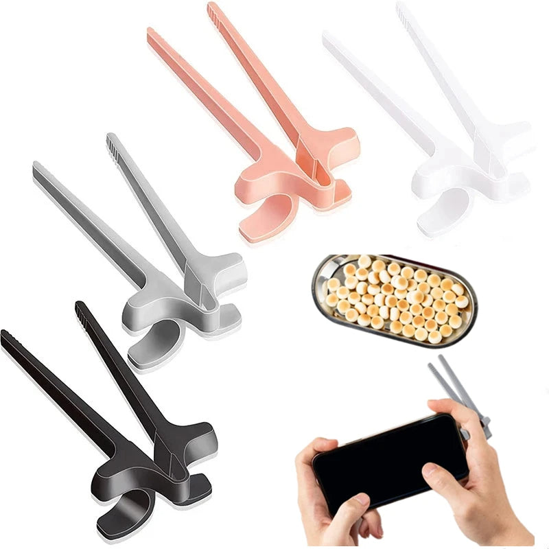 Set of four lip-shaped tools in black, gray, pink, and white, with a small container of snacks and a phone.