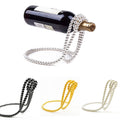 Bottle with a silver chain, gold chain, and black chain on a white background