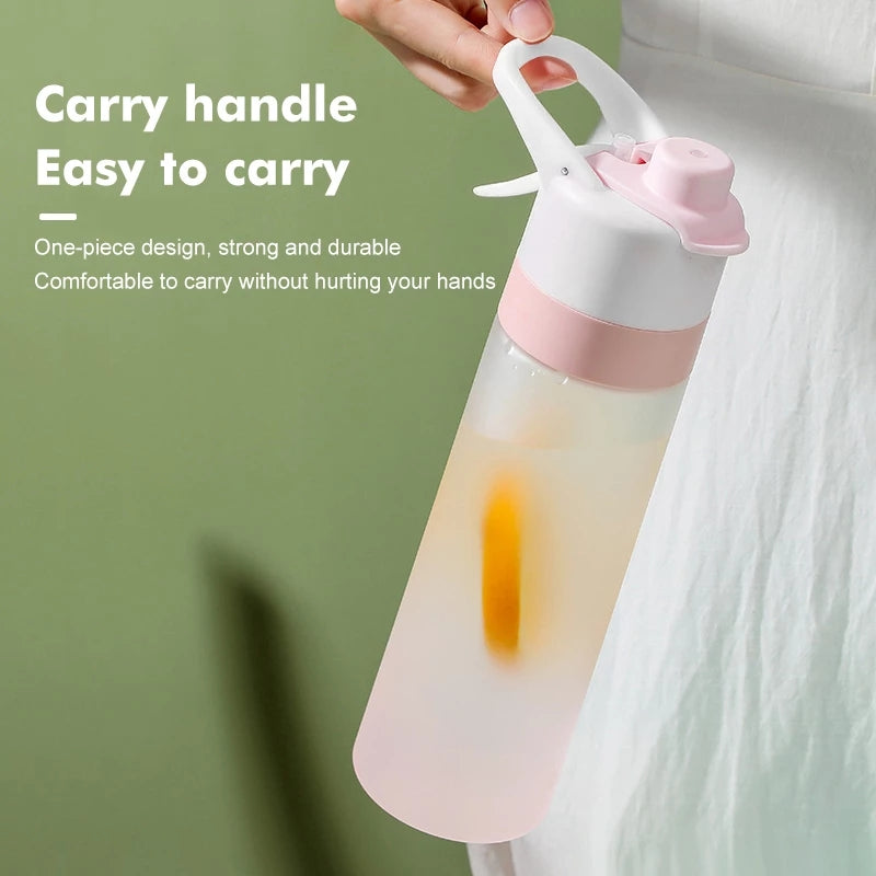 Pink water bottle with a handle held by a hand on a green background