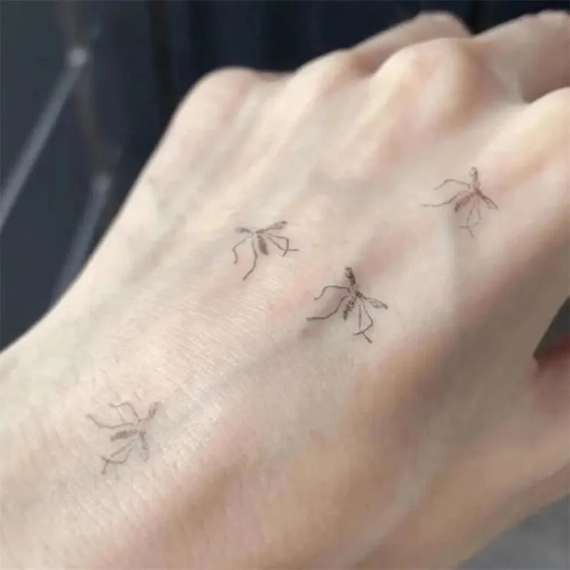 Small ant tattoos on a person's wrist