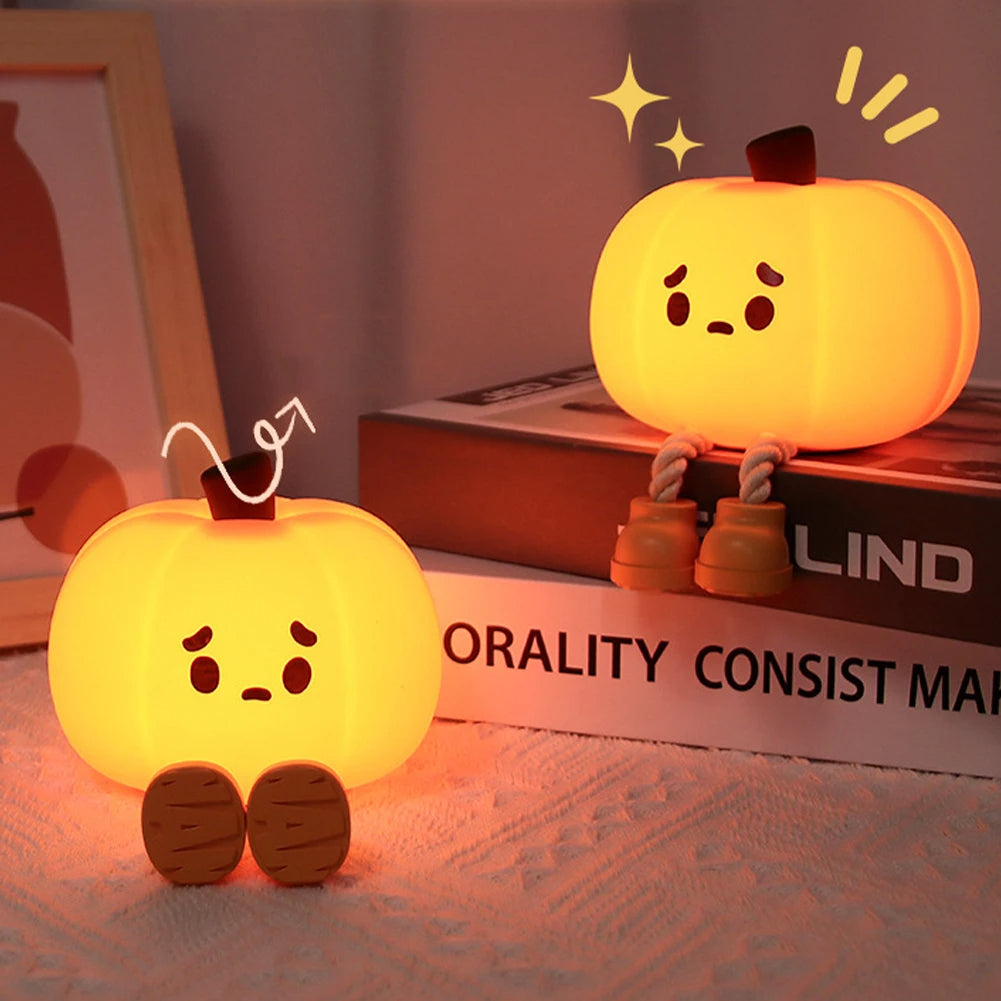 Two cartoon-style pumpkin lamps on a surface with a blurred background