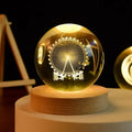 Glass ball with Ferris wheel design on a wooden base against a dark background