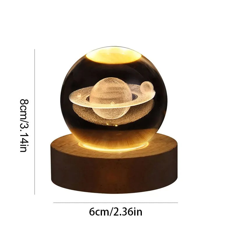 Glowing spherical object with planetary design on a wooden base, showing dimensions.