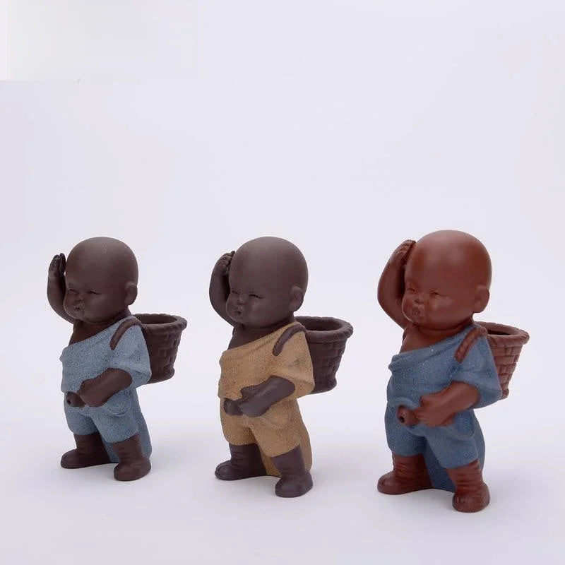 Three ceramic figurines of children holding baskets on a white background