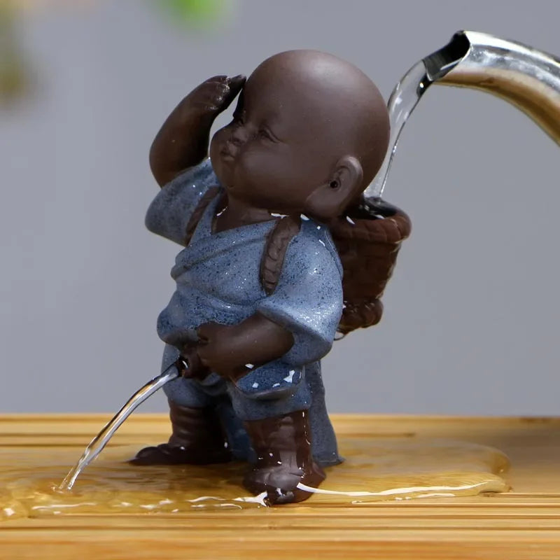 Tea infuser shaped like a monk with water flowing from a faucet