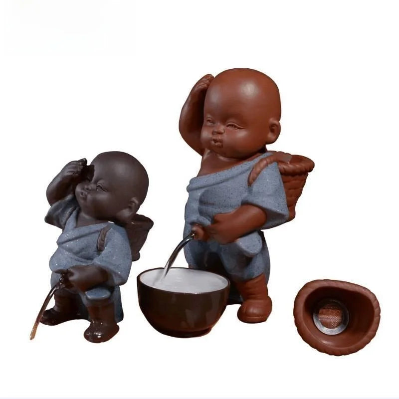 Two ceramic figures of children with a bowl and spoon on a white background